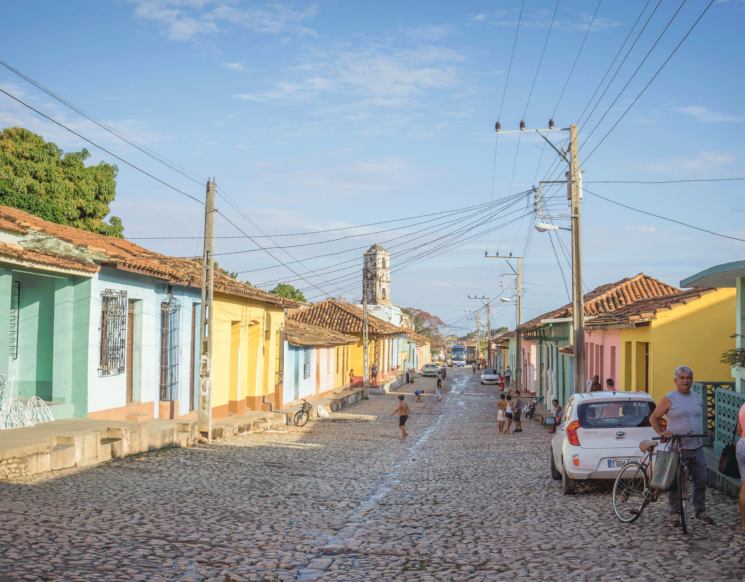 Bunte Häuser säumen die gepflasterte Straße auf der Kinder spielen in Kuba, Trinidad.