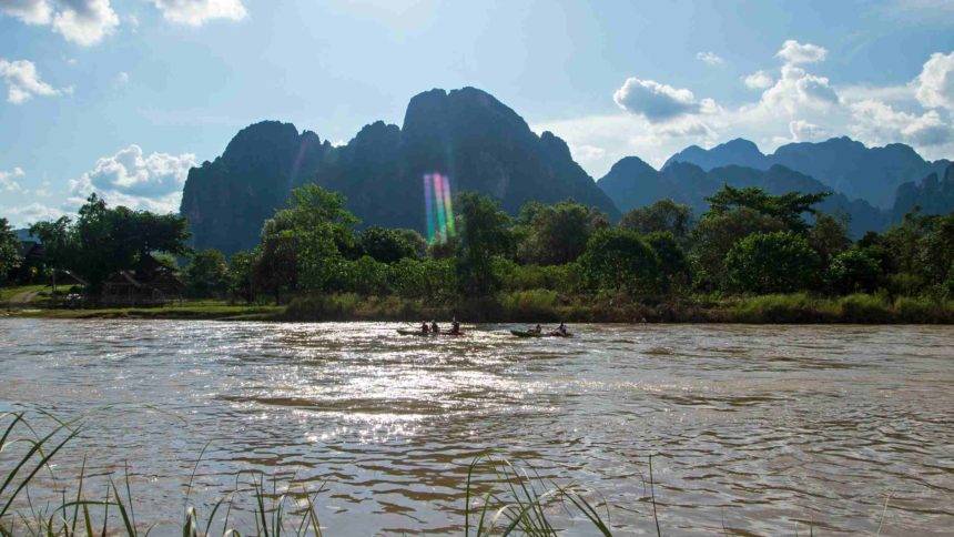 Auf dem Fluss Nam Song lässt es sich umgeben von grüner Natur hervorragend mit dem Kajak in den Sonnenuntergang paddeln.
