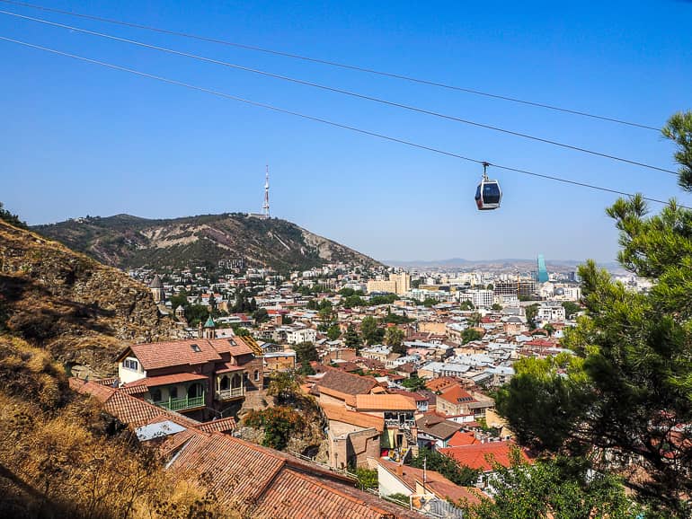 Eine Seilbahn gleitet über den Dächern der Stadt Tiflis seines Weges Richtung Hausberg Mtatsminda.