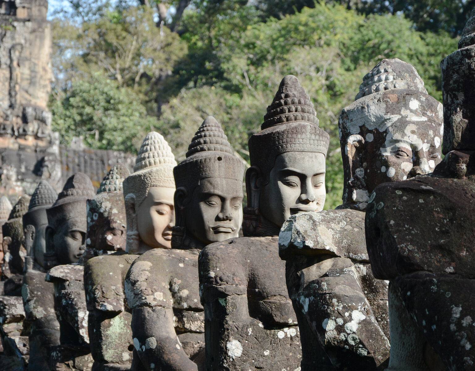 Riesige Buddha Statuen aus Stein stehen aneinandergereiht in Kambodscha auf der Rundreise von Pnom Penh nach Siem Reap, Angkor.