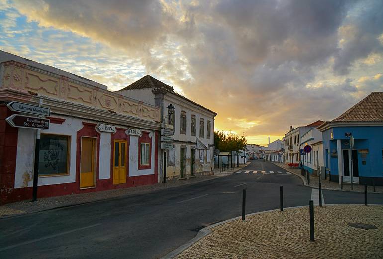 Der Winterhimmel der Algarve taucht die bunten Häuser an einem Straßeneck in ein mildes Licht.