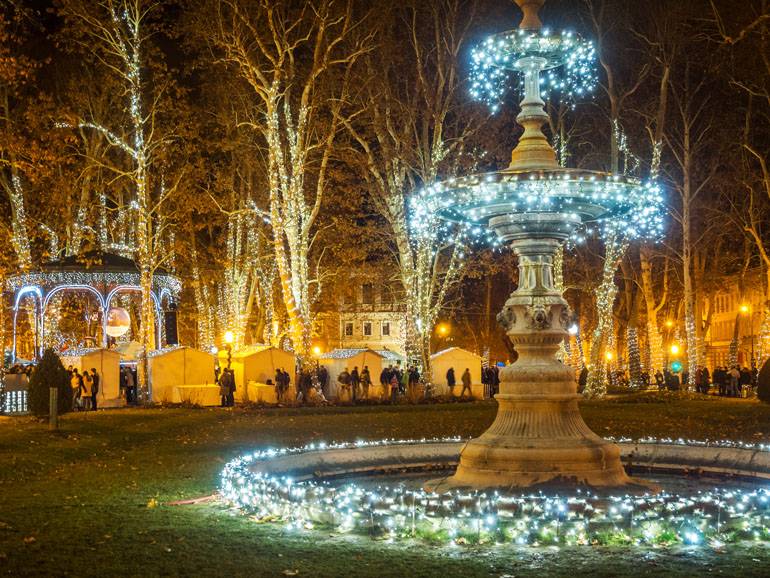 Der Springbrunnen auf dem Adventsmarkt in Zagreb verwandelt sich in einen funkelnden Adventskranz.