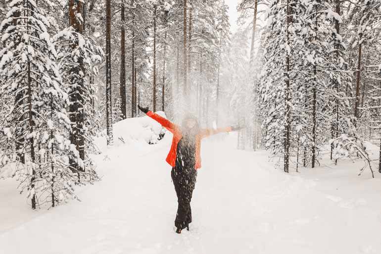 Eine Frau steht in einer Schneelandschaft in Finnisch Lappland.