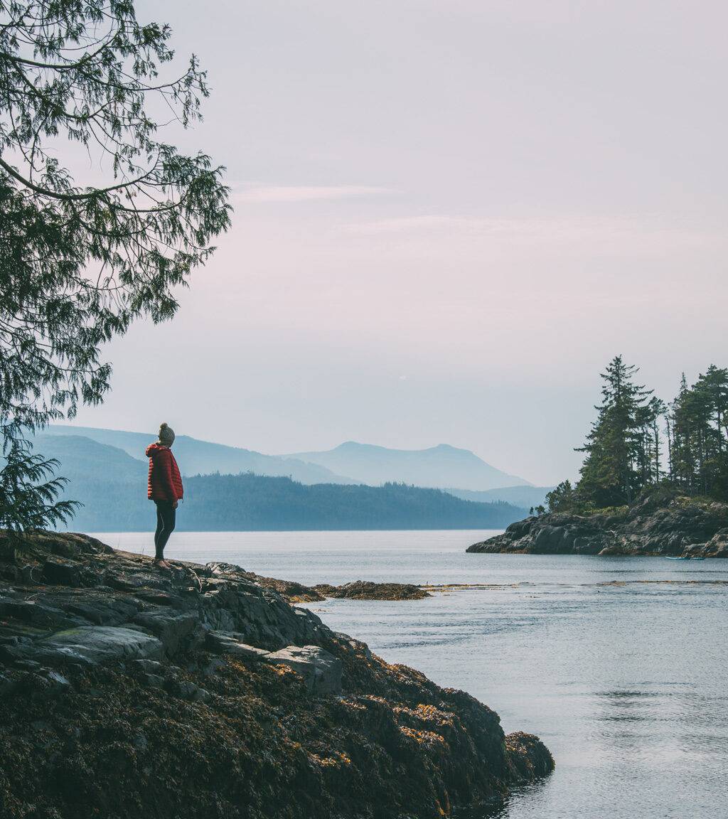 Vancouver Island: Eine Frau steht auf einem Felsen mit Blick auf das Meer.