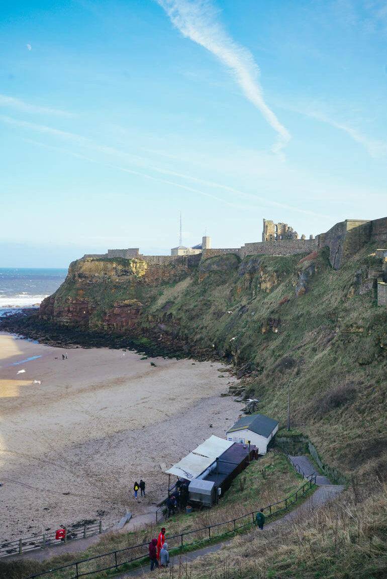 Eine Felswand mit einem kleinem Strand davor.