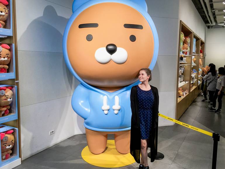 Seoul Sehenswürdigkeiten: Im Kakao Friends Store in Seoul steht eine Frau neben einem riesigen Bären.