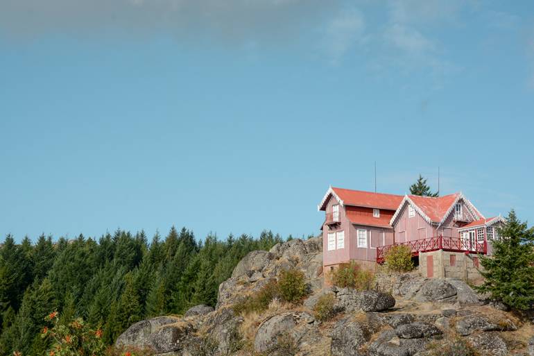 Ein rotes Haus das auf einem Berg steht.