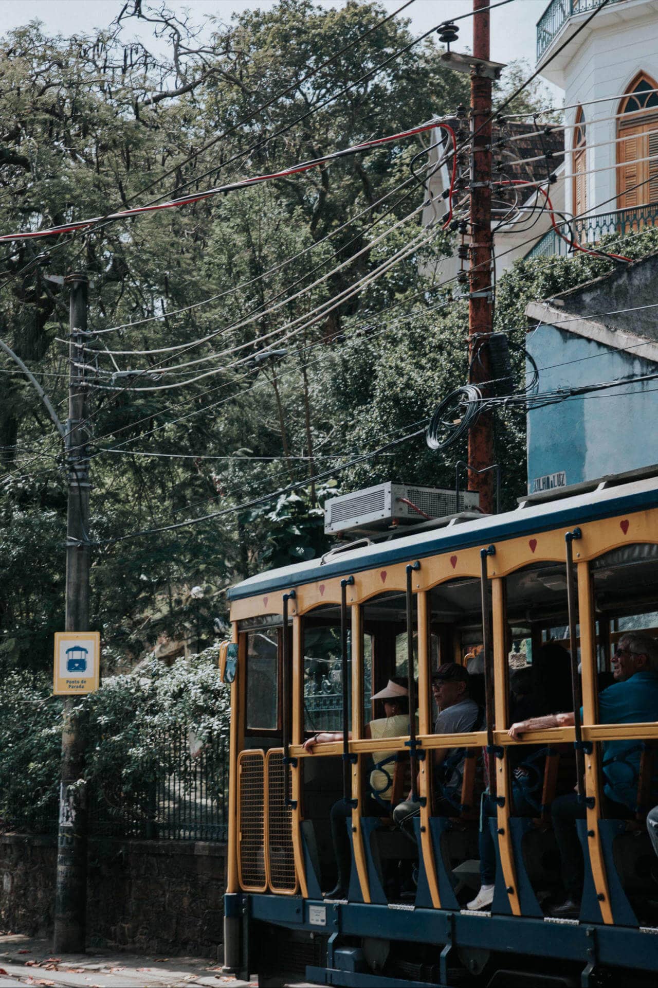 Eine gelbe Straßenbahn vor einem Haus.