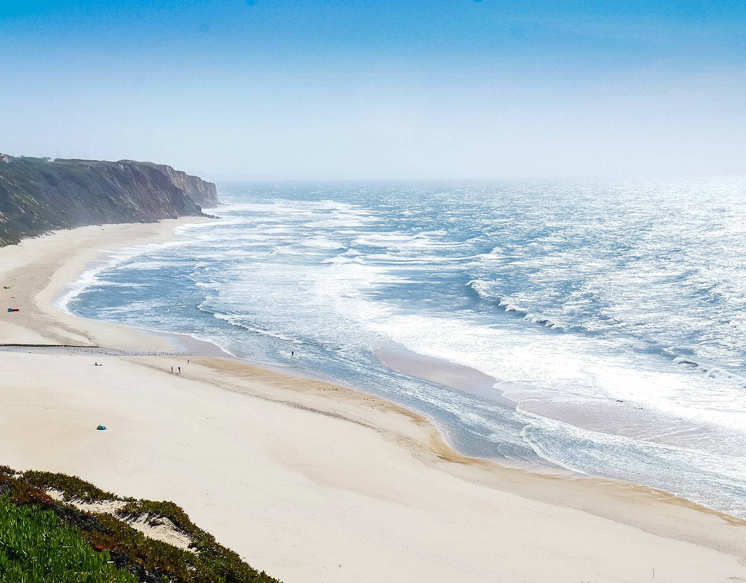 Strand an der Atlantikküste in Portugal mit hohen Wellen lockt Surfer aus aller Welt an.