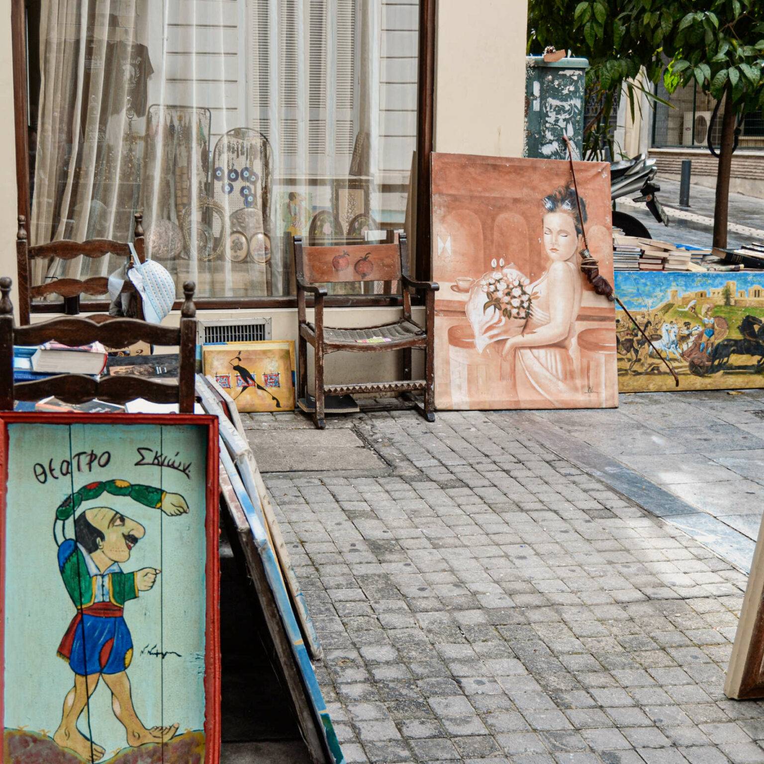 Gemälde lehnen an einer Hauswand auf einem Flohmarkt in Athen.