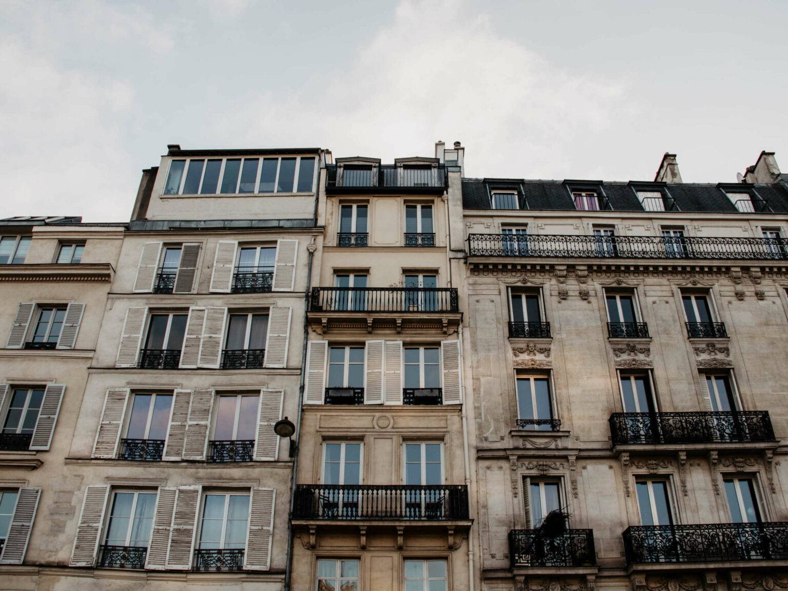 Imposanten Häuserfassaden mit verschnörkelten Balkongeländern begegnen Besuchern an vielen Ecken in Paris.