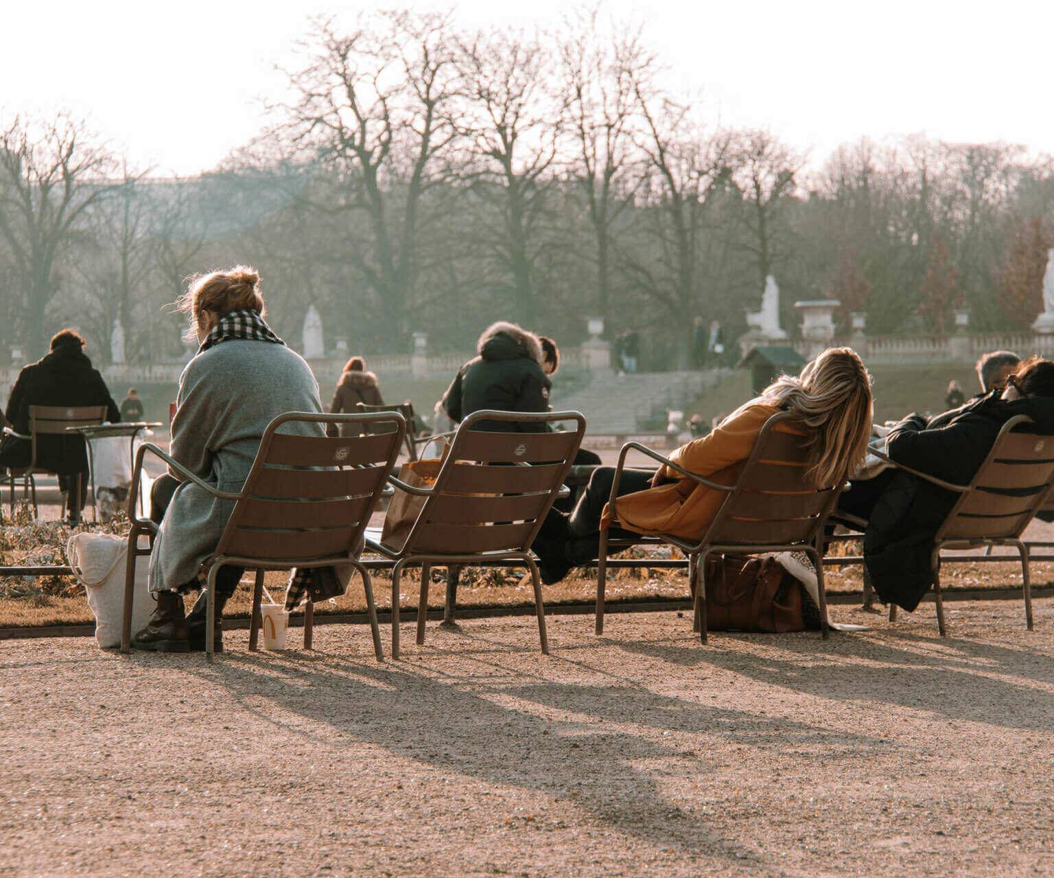 Im Jardin du Luxembourg in Paris genießen Einheimische wie Reisende die Sonnenstrahlen auf den Stühlen für Besucher.