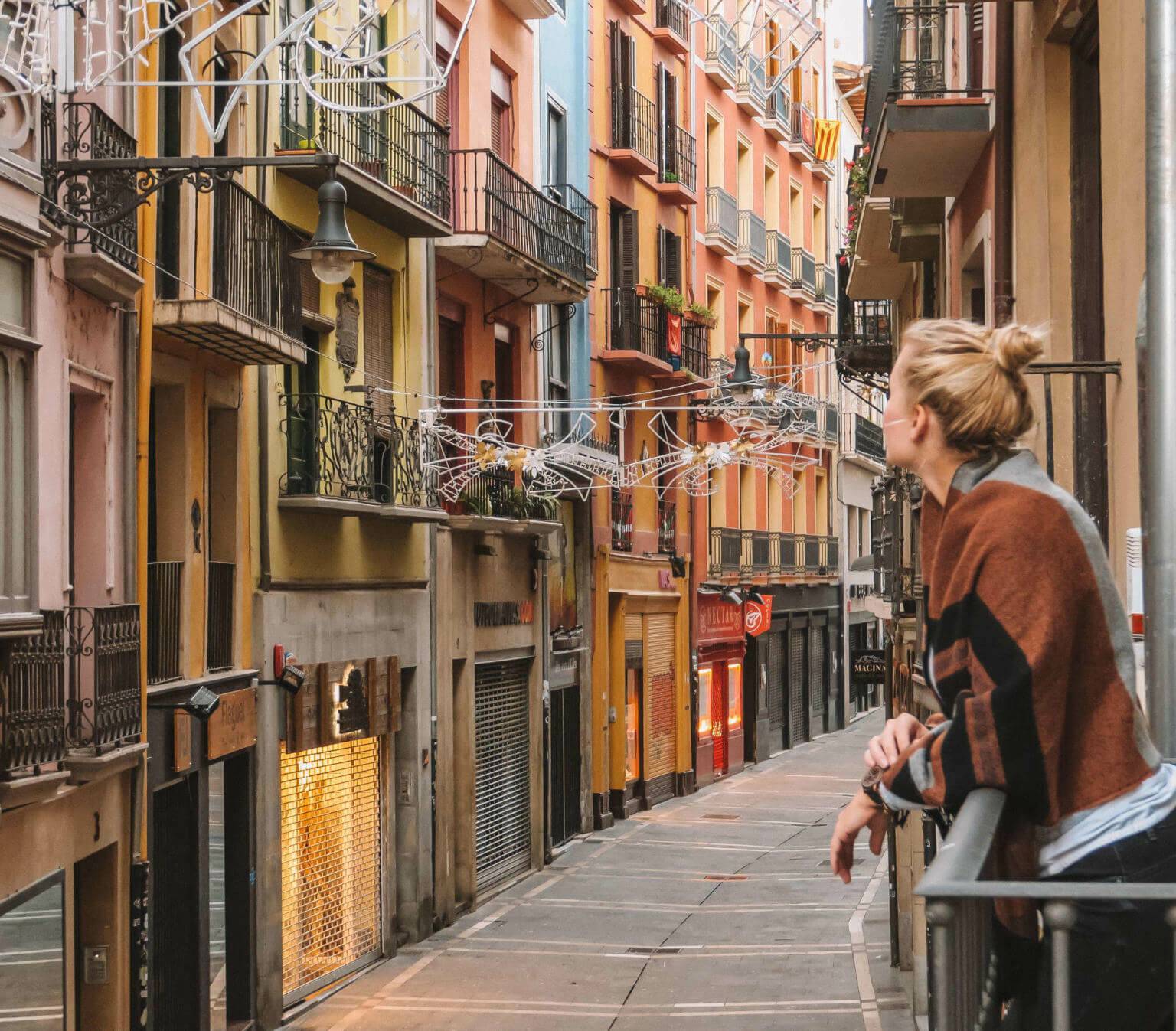Reisebloggerin Nina genießt den Ausblick von einem kleinen Balkon in einer schmale Gasse der spanischen Stadt Pamplona.