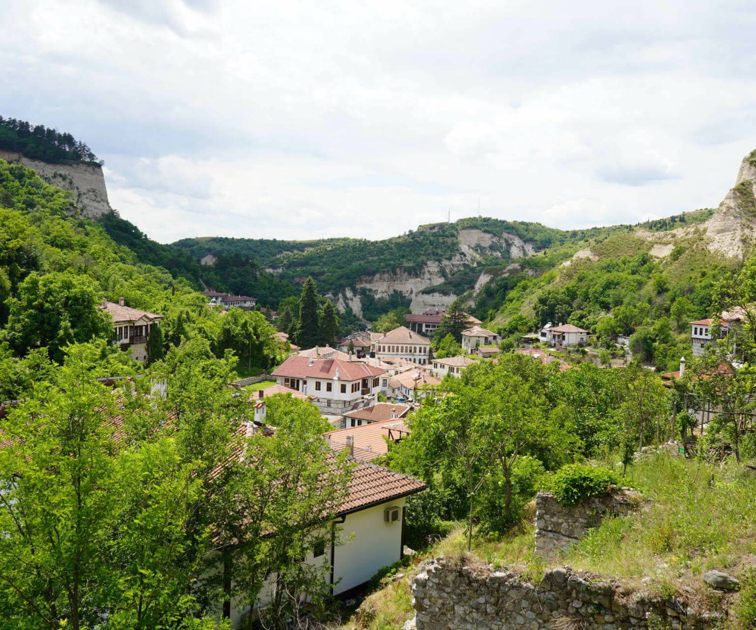 Von oben blickt man über die Häuserdächer und Natur der bulgarischen Stadt Melnik.