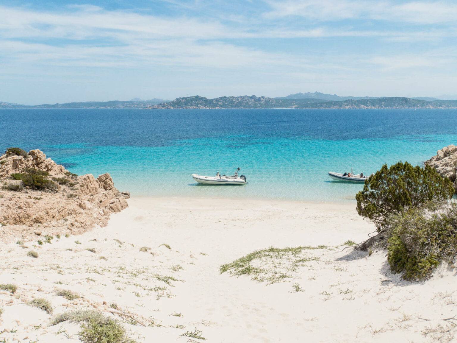 Einige Boote schwimmen auf dem klaren Wasser im Norden von Sardinien.