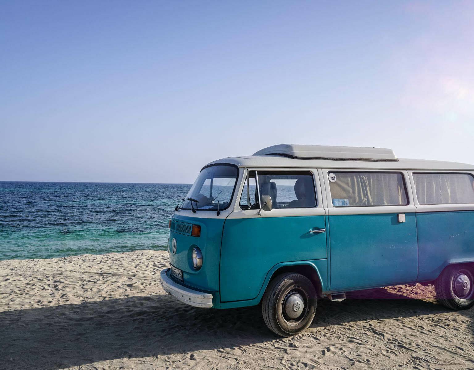 Am Playa de Migjorn auf Formentera steht ein alter blauer VW Bulli - die Hippiekultur der Insel sollte man gesehen haben.