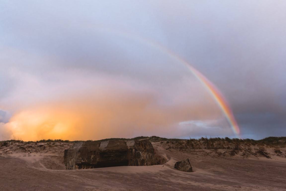 Ein Regenbogen bildet sich über dem Strand an der Westküste Dänemarks.