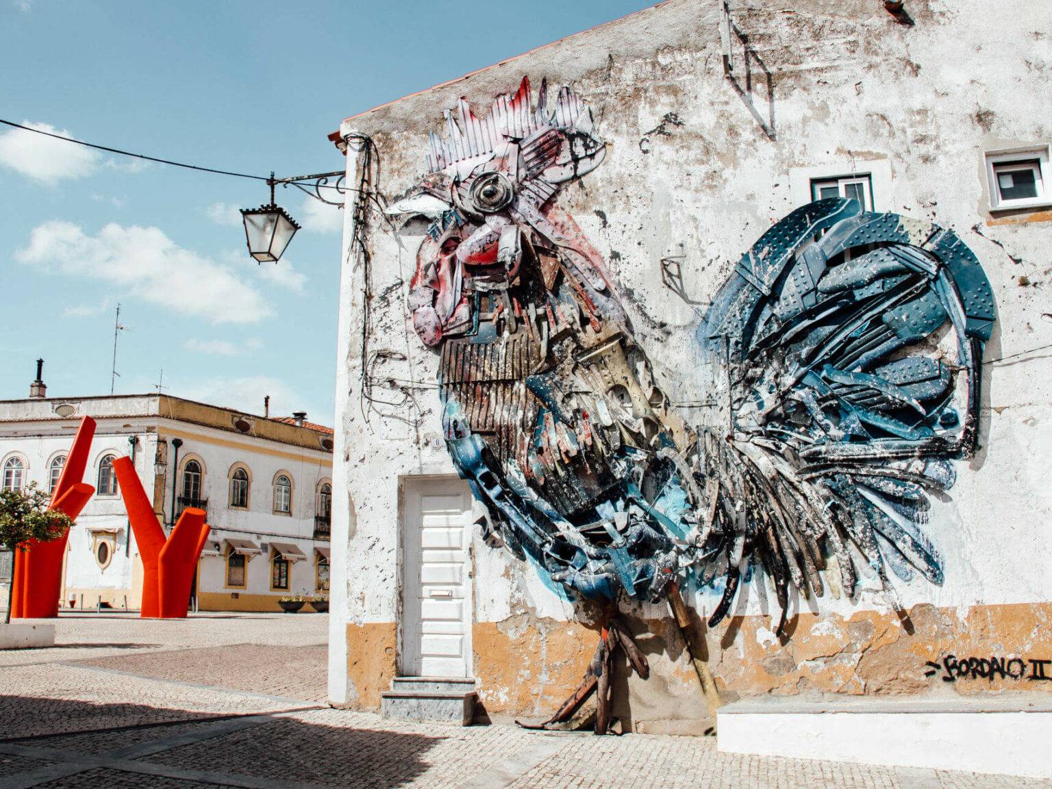 Ein riesiger künstlerischer Hahn verziert die Wand eines Gebäudes. Eine Sehenswürdigkeit von den Straßen des Alentejos.