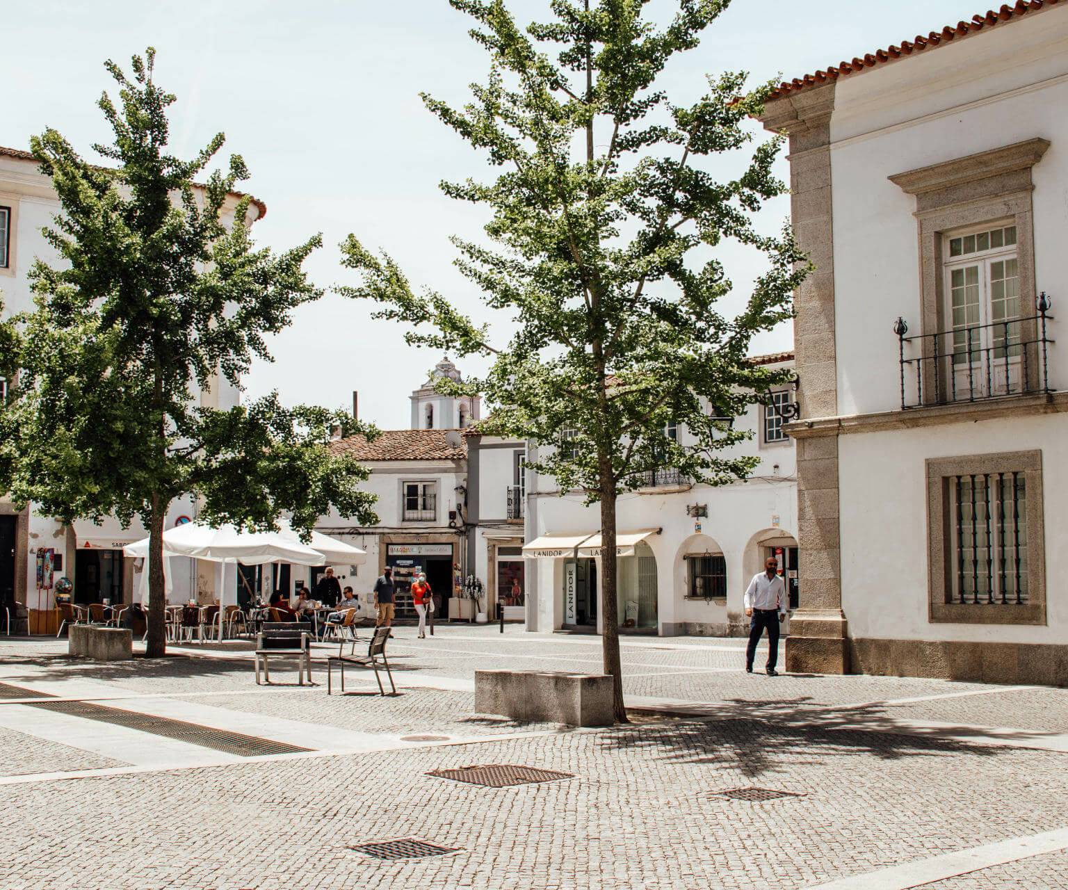 Ein schön gepflasterter Platz mit einem Außenbereichs eines Cafés in der Altstadt in Evora im Alentejo.