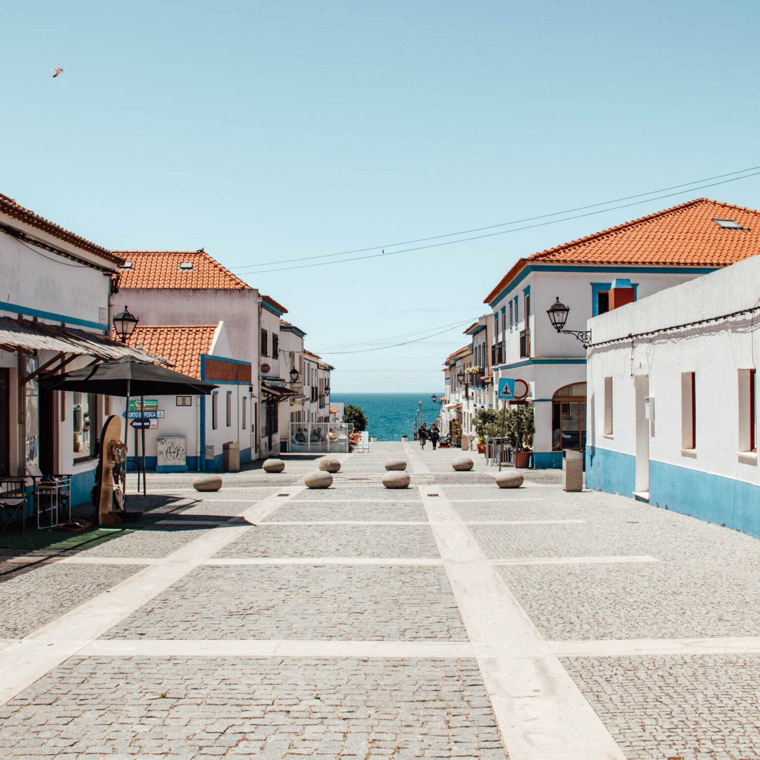 Kleine Straße mit Häusern im portugiesischen Stil hin zum Meer an der Algarve