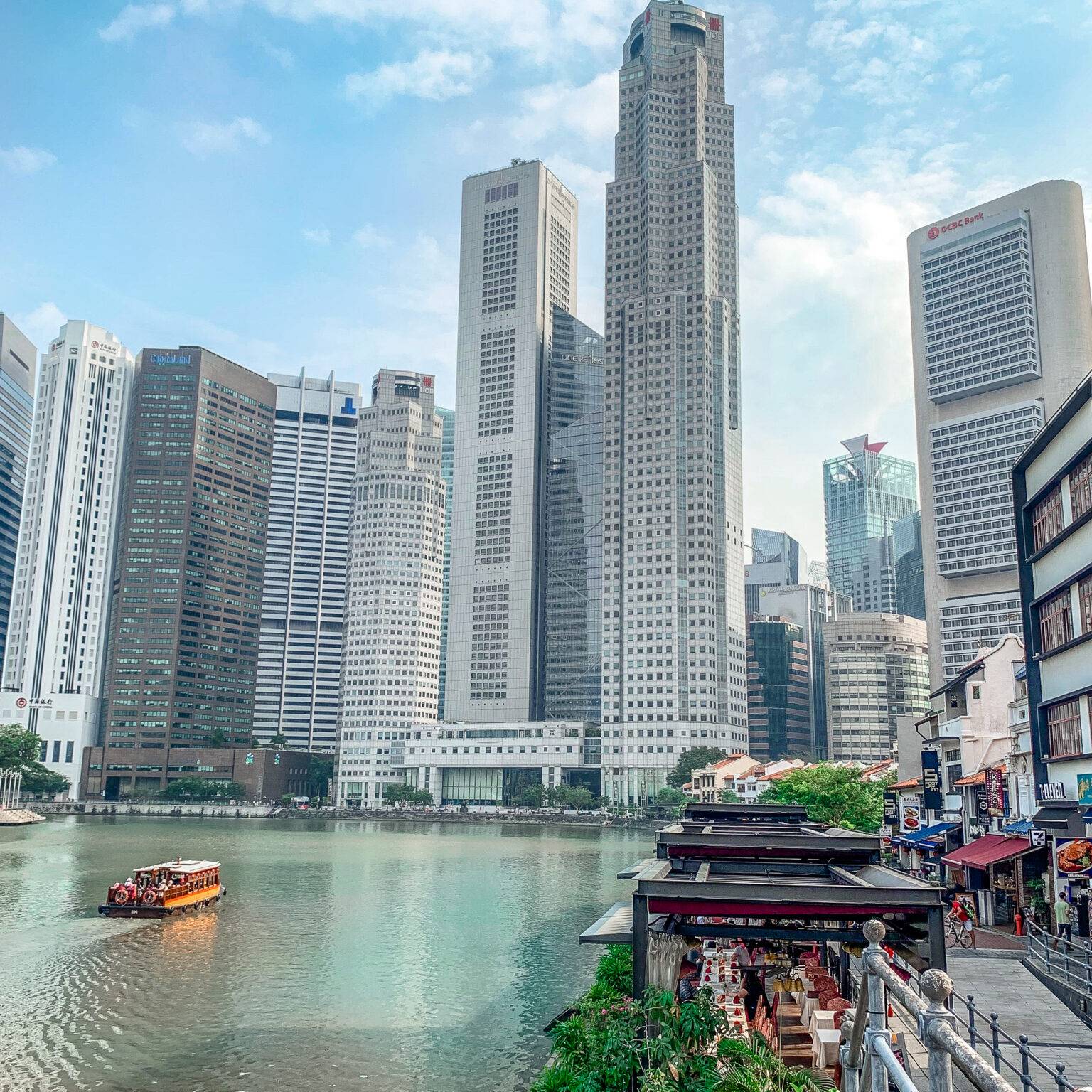 Der Boat Quay im Vordergrund mit Blick auf den Singapore River und vielen Hochhäusern.