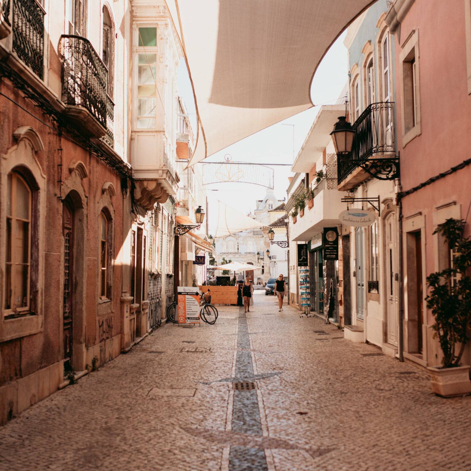 Eine ruhige Nebenstraßen in Faro, geschückt mit weißen Segeln die zwischen den Häusern hängen.