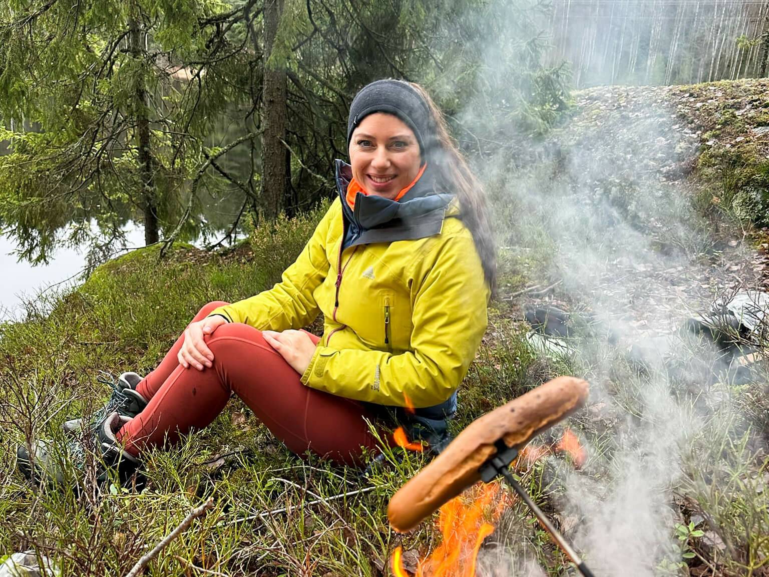 Bloggerin Biggi mit einer Bratwurst am Lagerfeuer im Wald von Oslo.