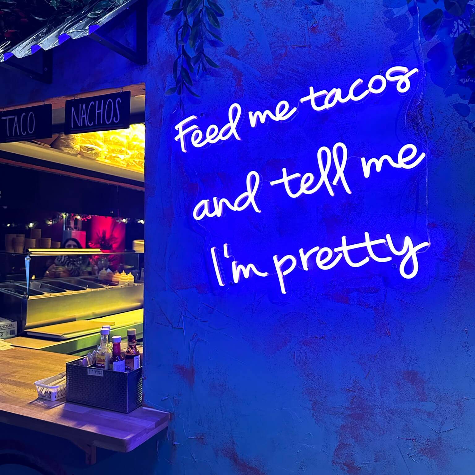 In blauer Leuchtschrift steht im Geheimtipp Street-Food-Laden Barcode in Oslo der Schriftzug "Feed me tacos and tell me I'm pretty".