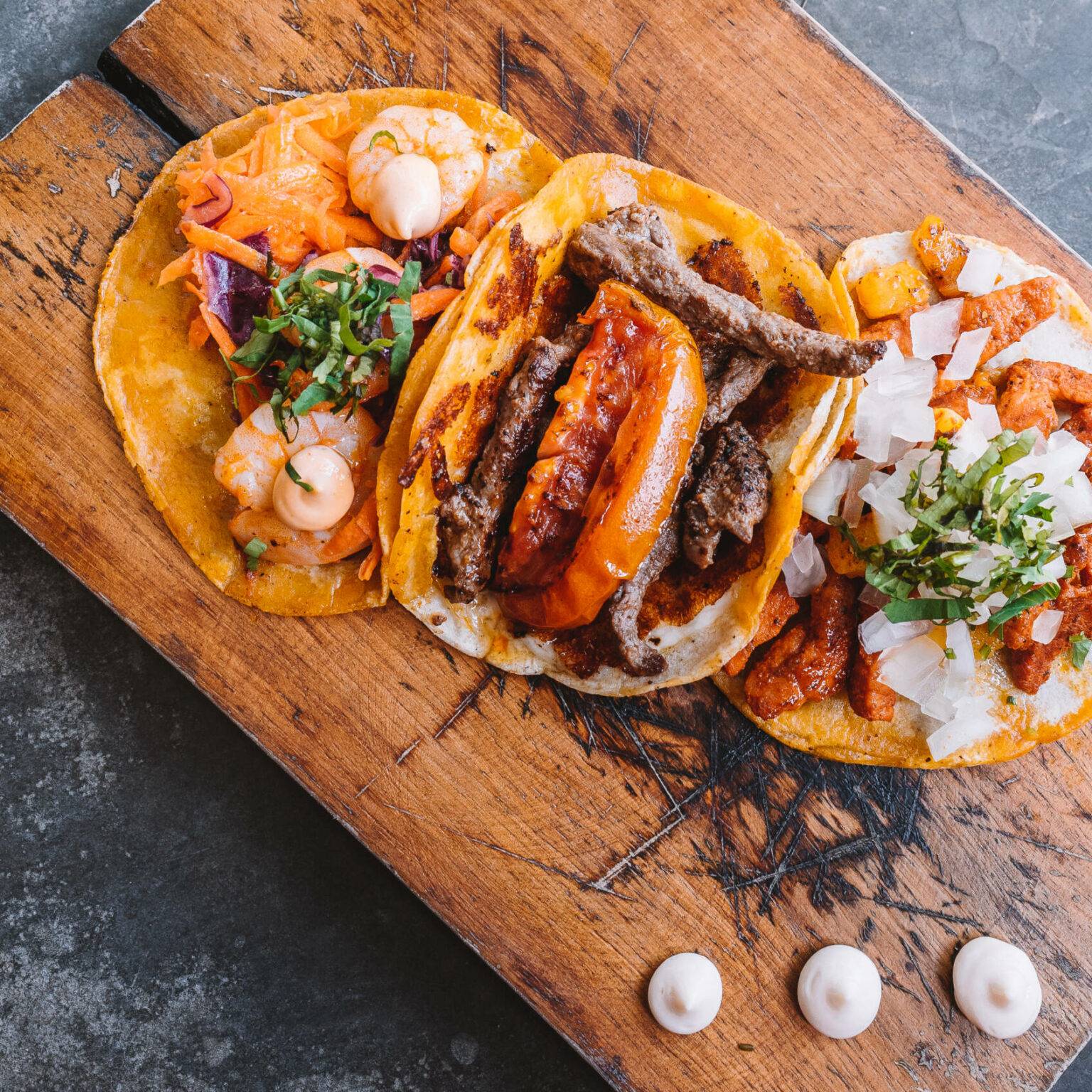 Tacos liegen angerichtet auf einem Holzbrett in der La Taqueria in Tulum auf Mexikos Halbinsel Yucatan.