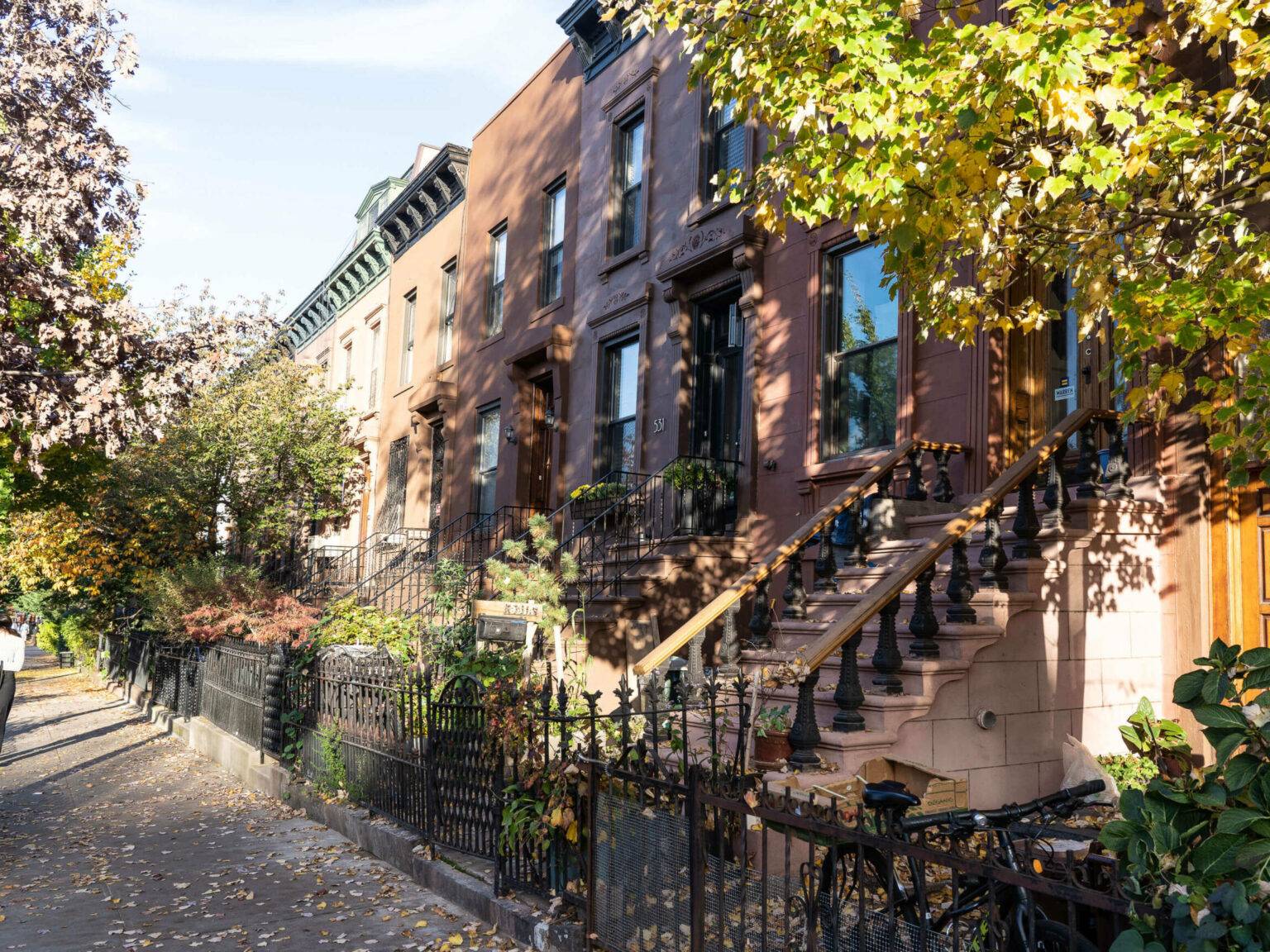 Die Brownstone Houses, ein Wahrzeichen von Brooklyn, sind Reihenhäuser in verschiedenen Brauntönen mit kleine Gärten und Treppen die zu den Häusertüren führen.