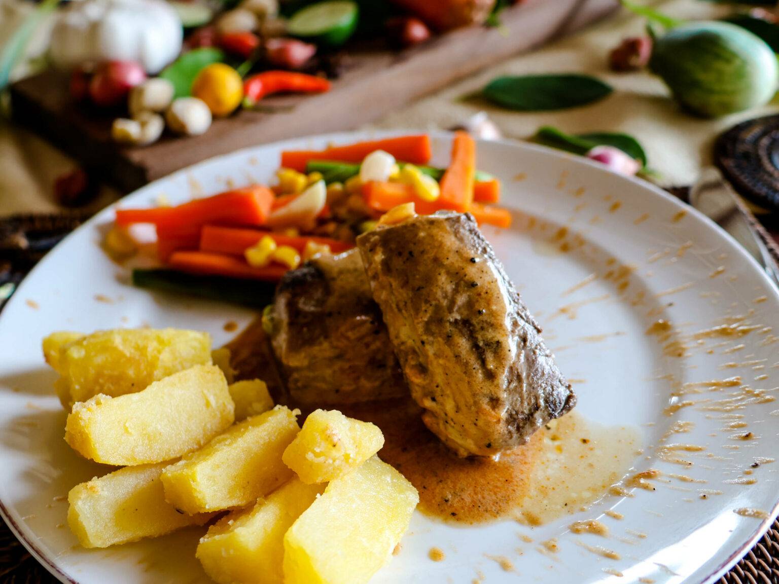 Ein Teller mit Kartoffeln, Fleisch und Gemüse aus dem Katembe Private Island Resort auf Raja Ampat.