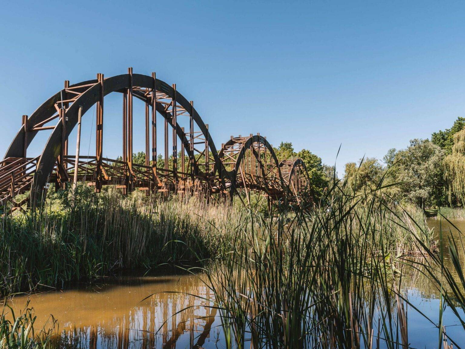 Eine alte Holzbrücke die über einen Teich in das Naturschutzgebiet Kis Balaton in Ungarn führt.