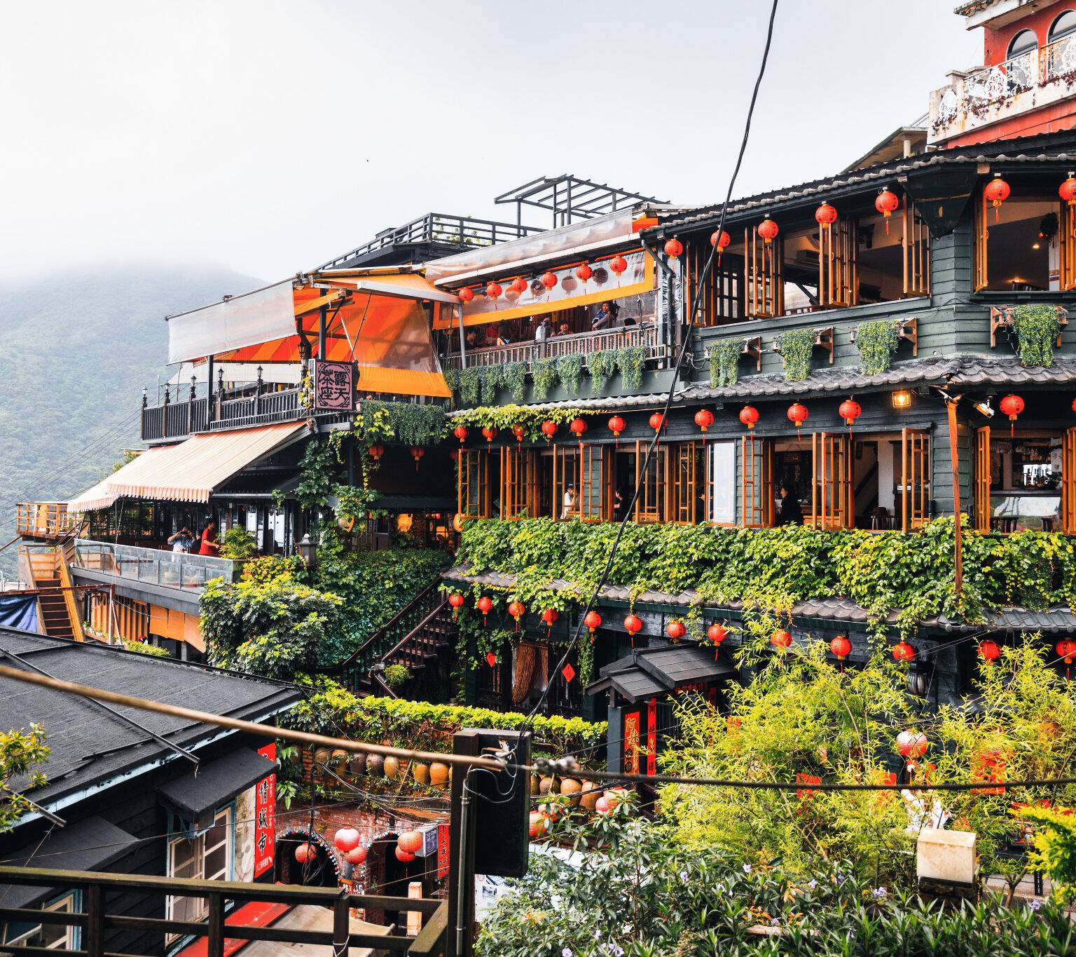 Die Häuser im Bergdorf Jiufen in Taiwan sind geschmückt mit orangenen Lampions.