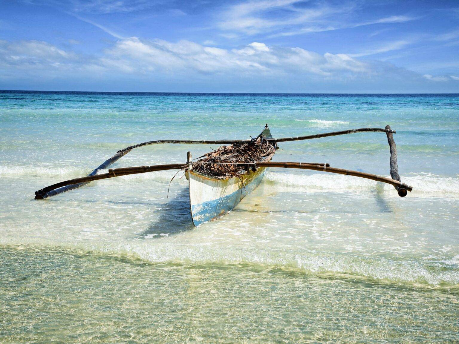 Ein altes Kanu aus Holz liegt an der Küste am Meer von Anda auf Philippinens Insel Bohol.