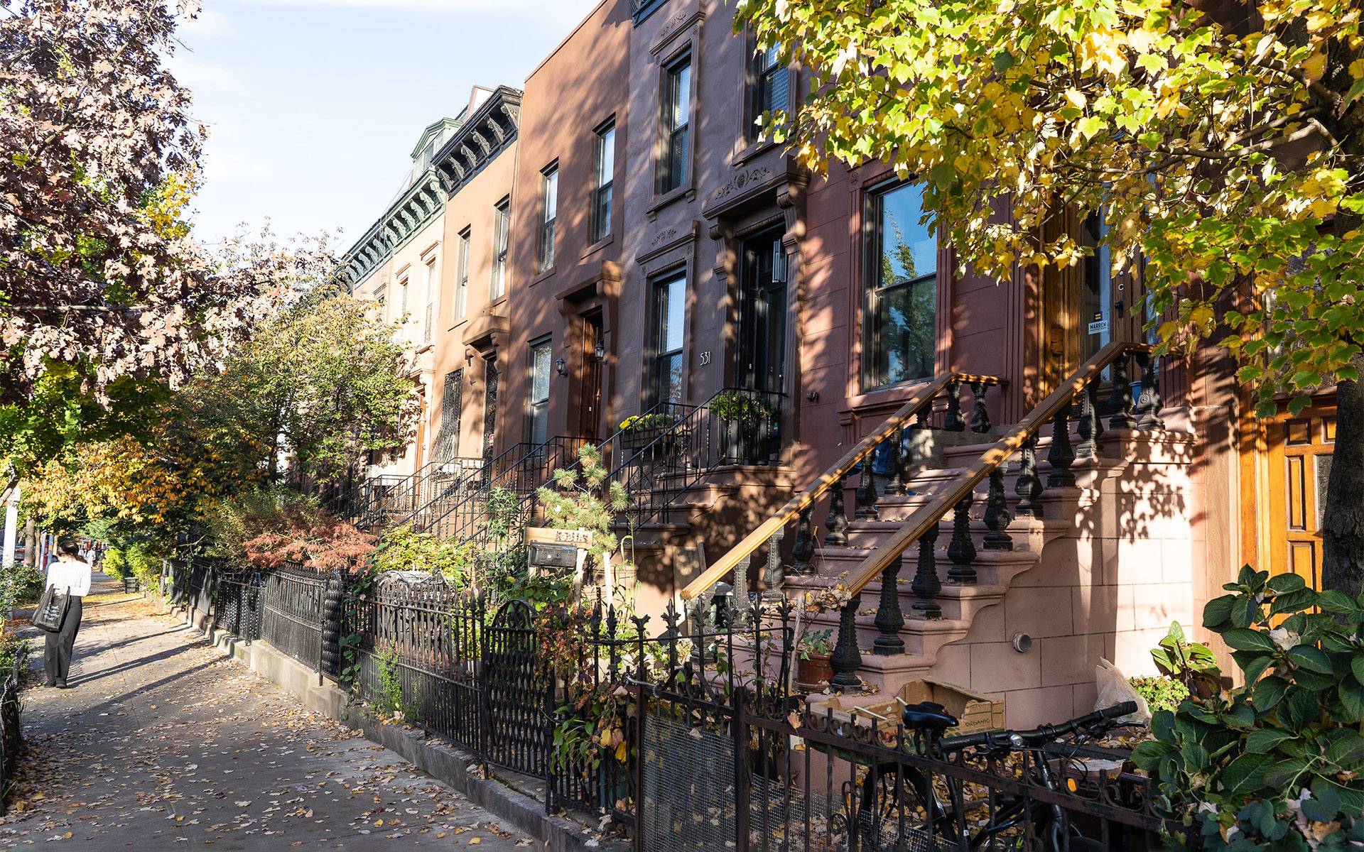 Die Brownstone Houses, ein Wahrzeichen von Brooklyn, sind Reihenhäuser in verschiedenen Brauntönen mit kleine Gärten und Treppen die zu den Häusertüren führen.