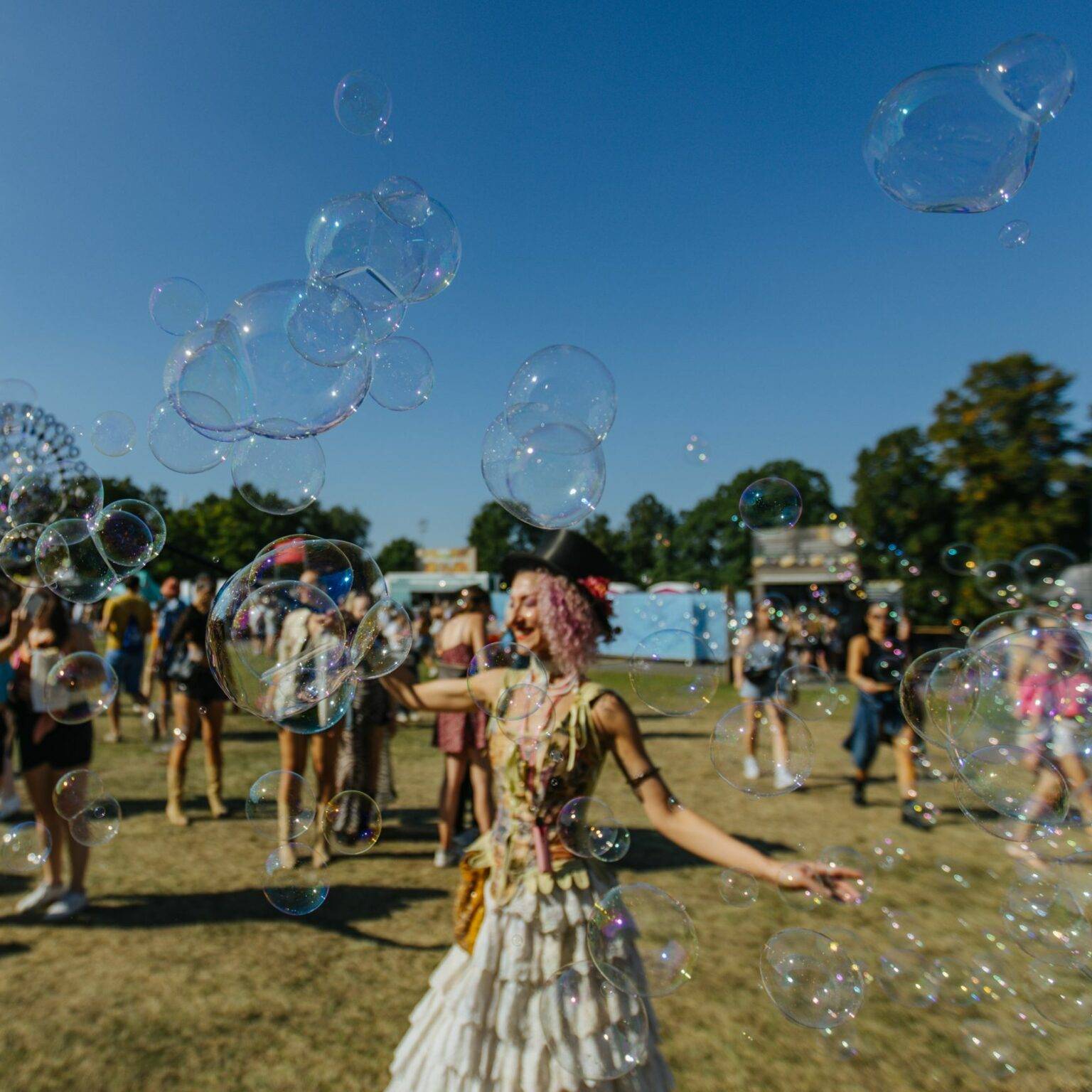 Eine Frau auf dem Festivalgelände umgeben von Seifenblasen.