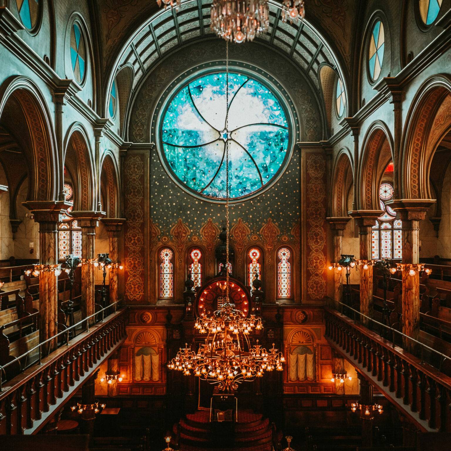 Ein großes, blaues Fenster überragt den Innenraum der Synagoge.