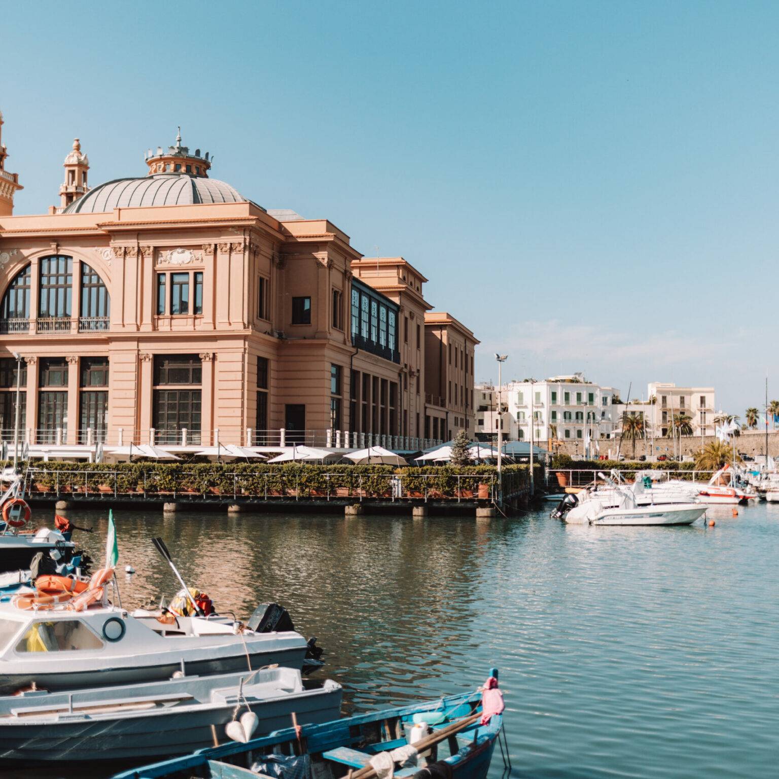 Blick auf den Hafen mit vielen Booten und im Hintergrund das ehemalige Theater von Bari.