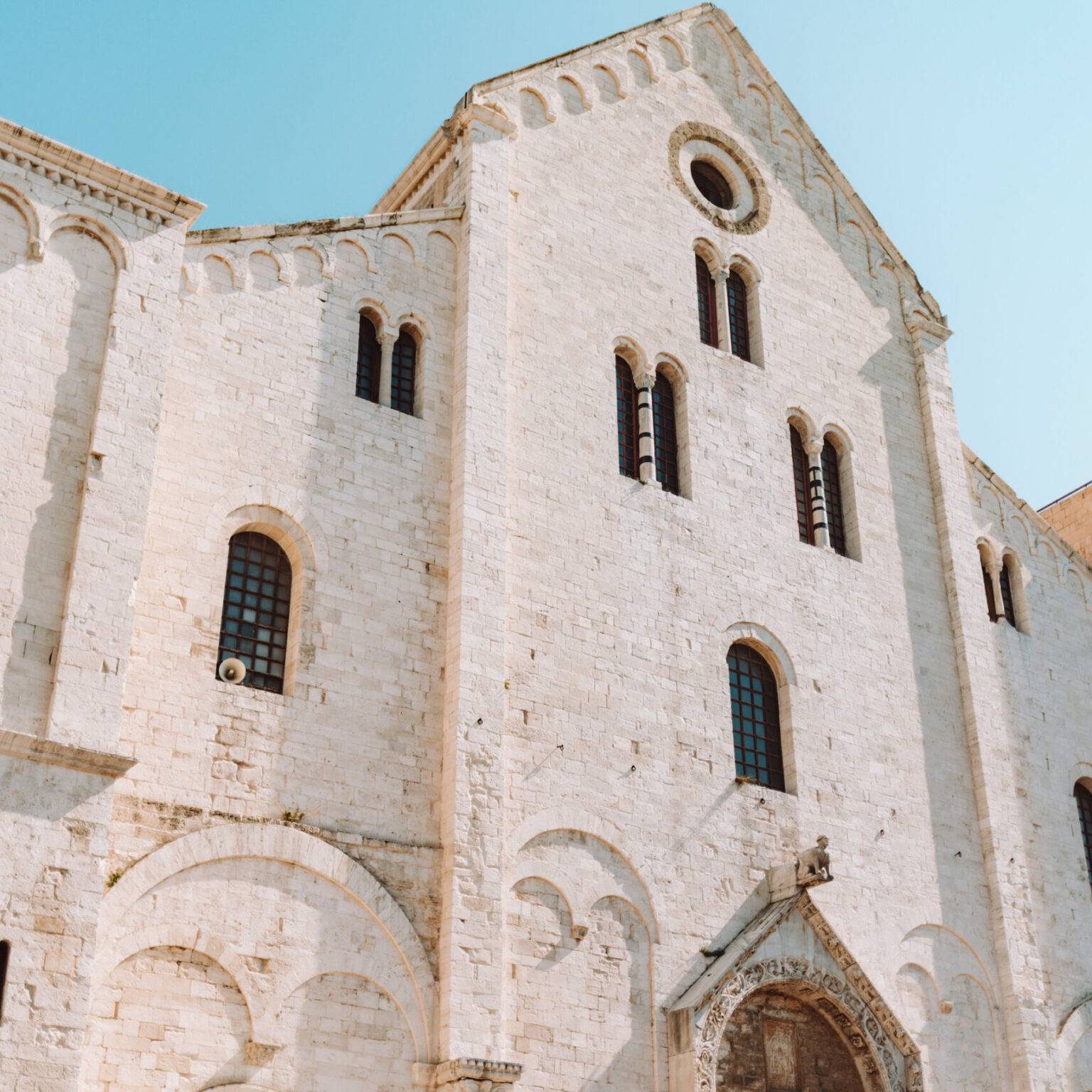 Die Basilika San Nicola in Bari mit ihrer hellen beigen Fassade aus Stein.