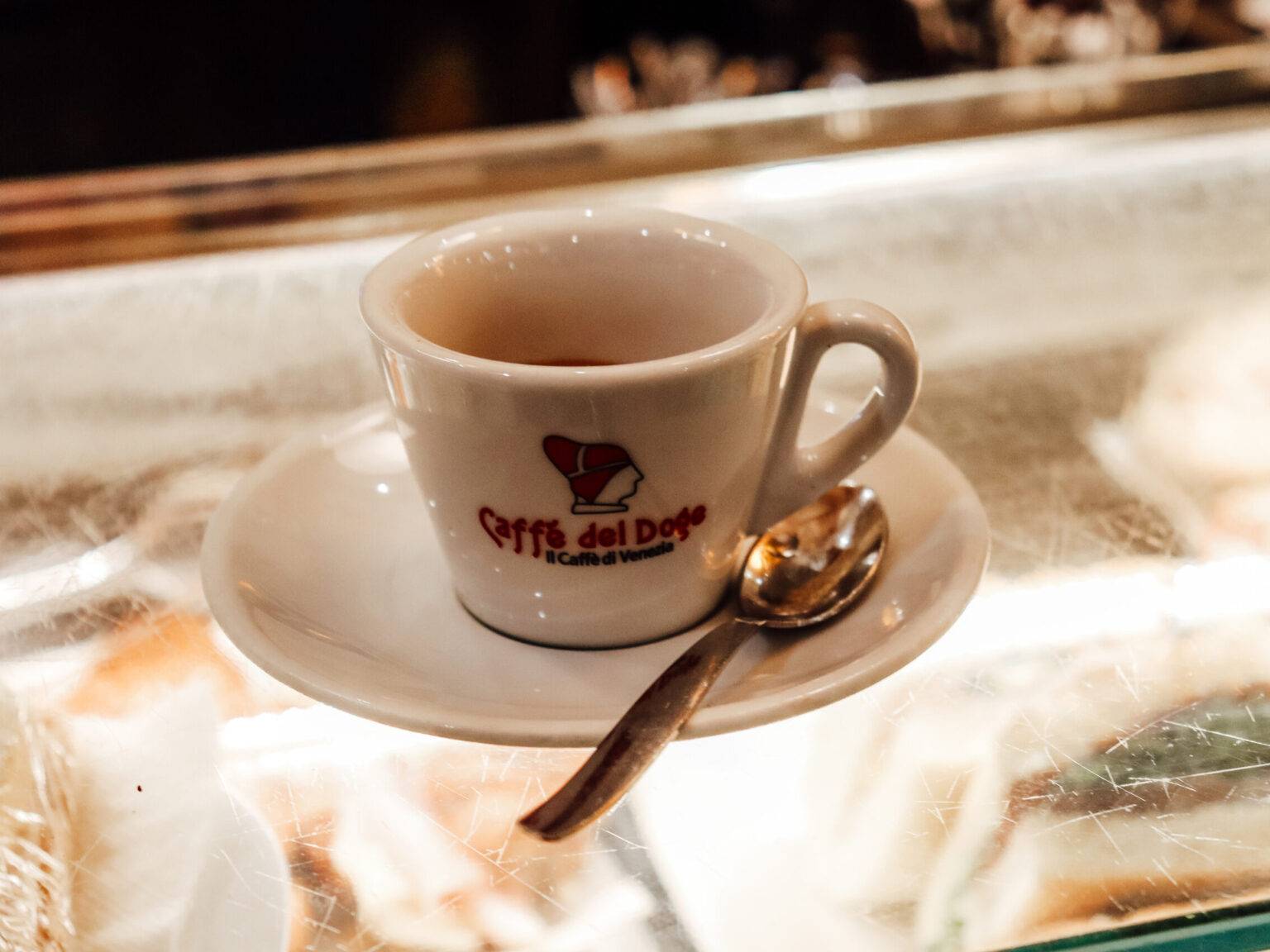 Ein Kaffee “al banco” auf einem gläsernen Tresen.