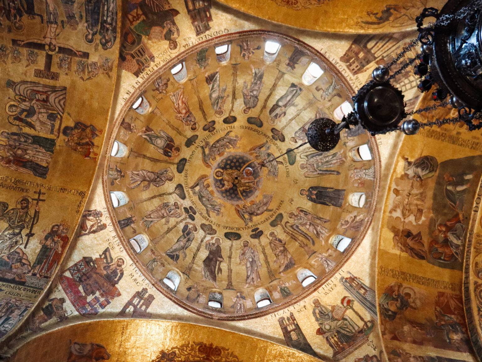 Goldene Kuppel mit leuchtenden Mosaiken im Inneren des Markusdoms in Venedig.