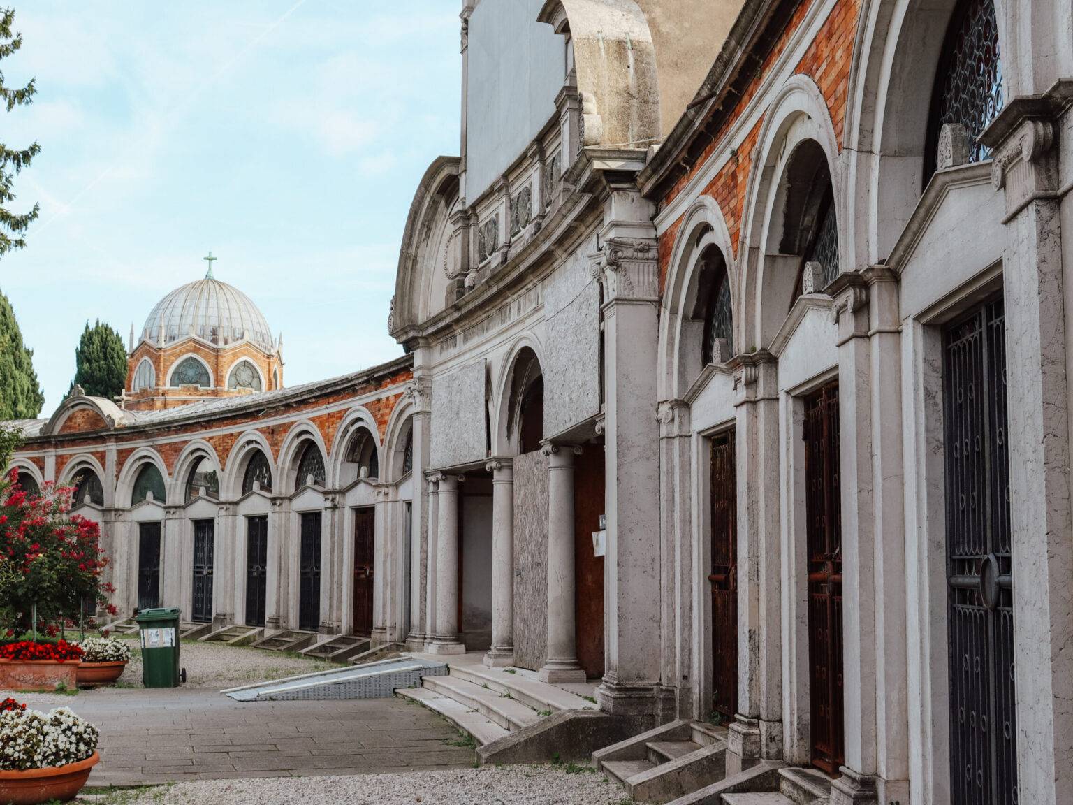 Ein längliches Gebäude mit aneinander gereihten Eingängen auf der Friedhofsinsel San Michele.