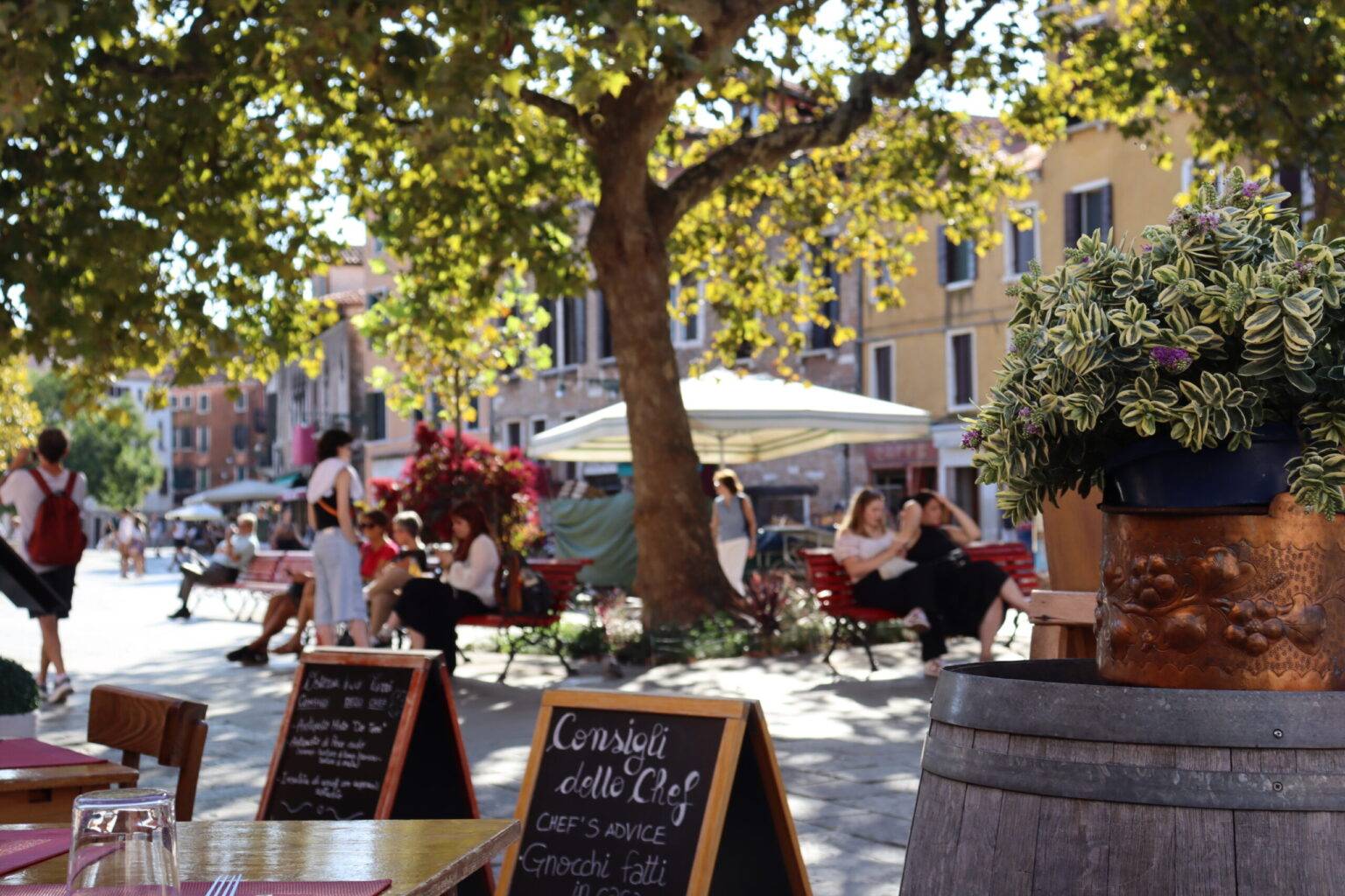 Ein Restaurant mit vielen besetzten Plätzen draußen auf dem Platz Santa Margherita.