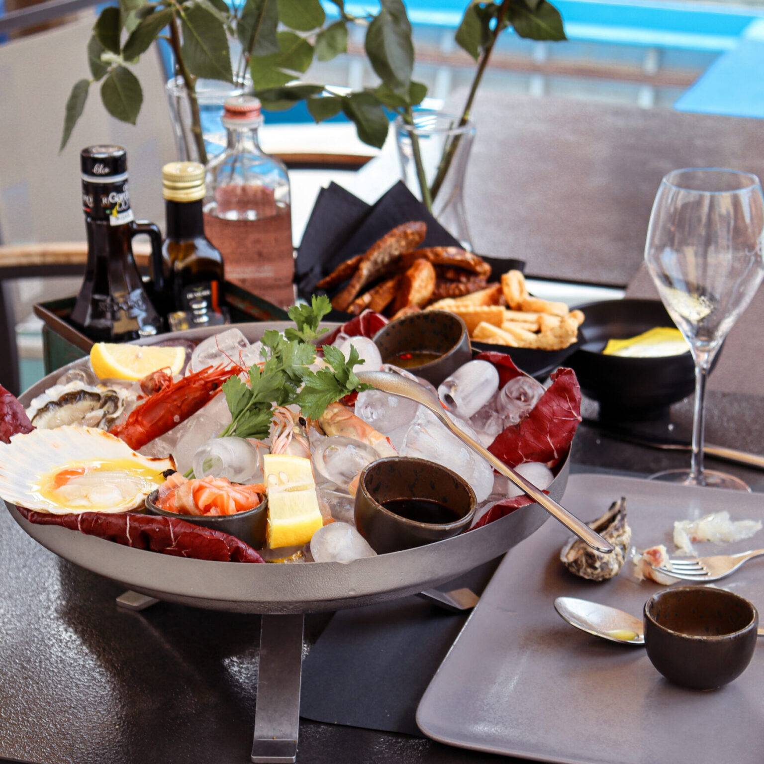 Auf einem Tisch steht eine große Platte mit verschiedenen Meeresfrüchten auf Eis.