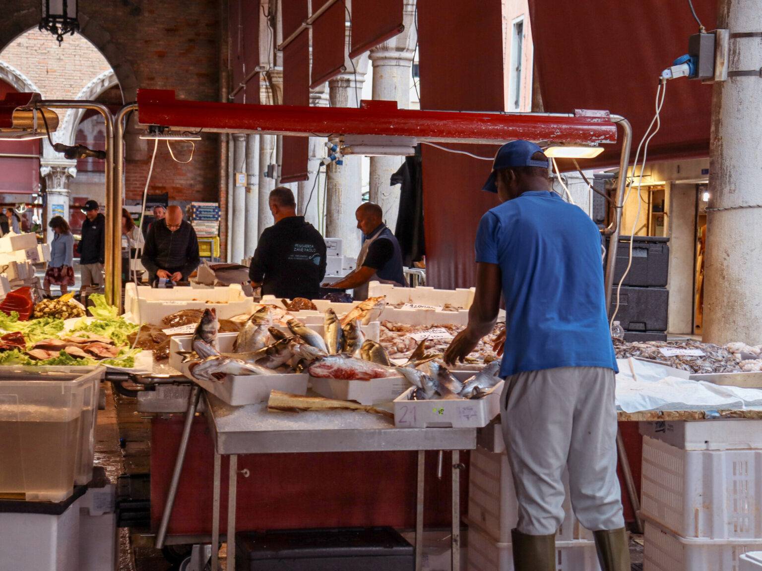 Die Halle des Fischmarkts an der Rialtobrücke mit einem Fischhändler bei der Arbeit.