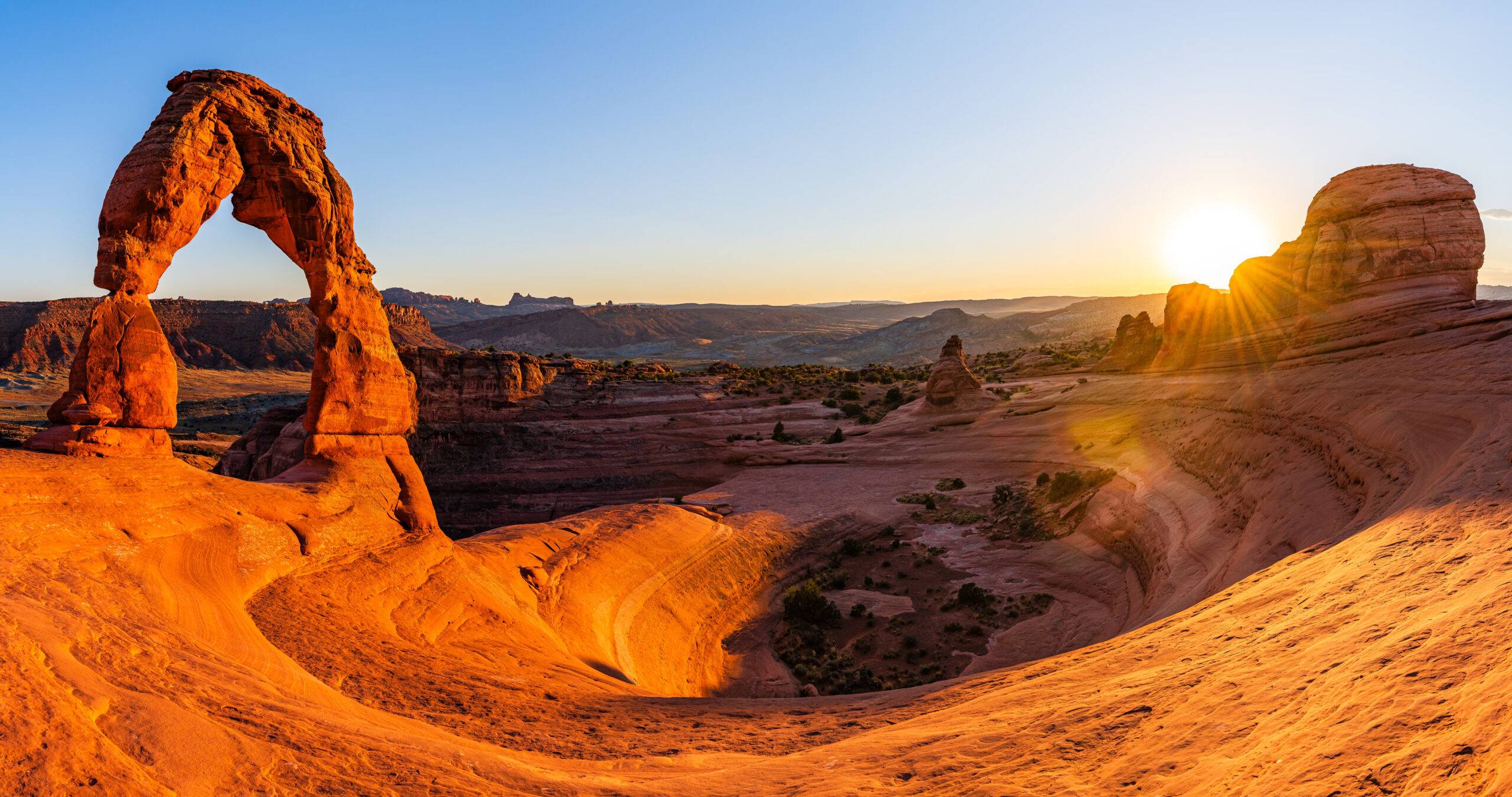 Delicate Arch, die berühmteste Felsformation im Arches National Park in Utah, leuchtet in kräftigen Rottönen im Abendlicht.