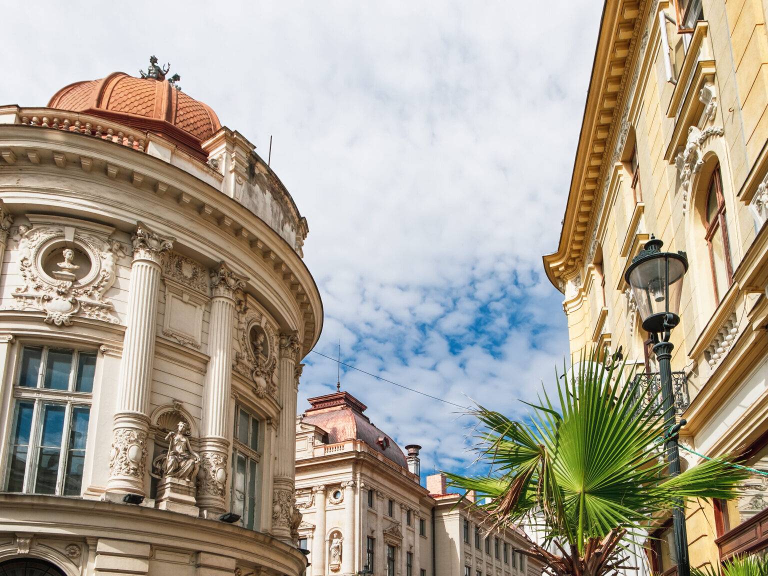 Die Fassaden von mehreren alten Gebäuden in der Altstadt Lipscani von Bukarest mit Säulen, Figuren und detaillierten Verzierungen.