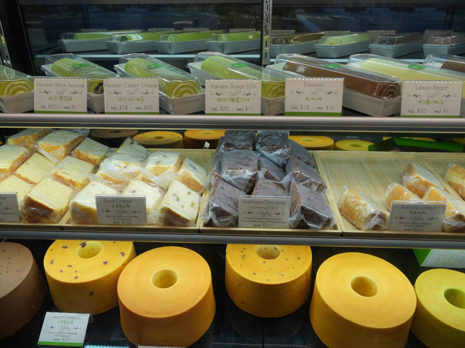 Regal mit verschiedenen Käsesorten und Desserts, verpackt und beschriftet.