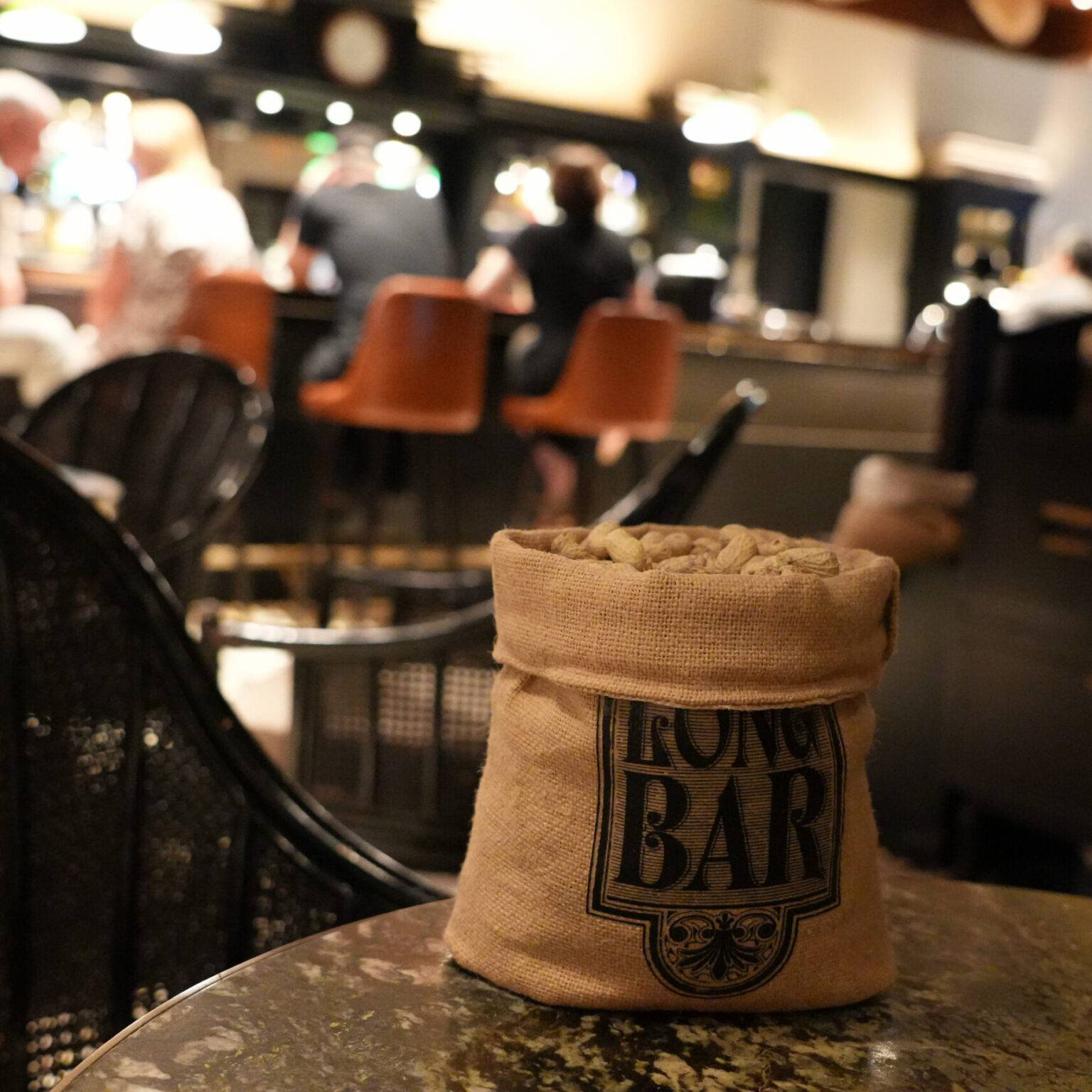 Ein kleiner Jutesack voll mit Erdnüssen auf einem Tisch in der Long Bar des Raffles Hotels