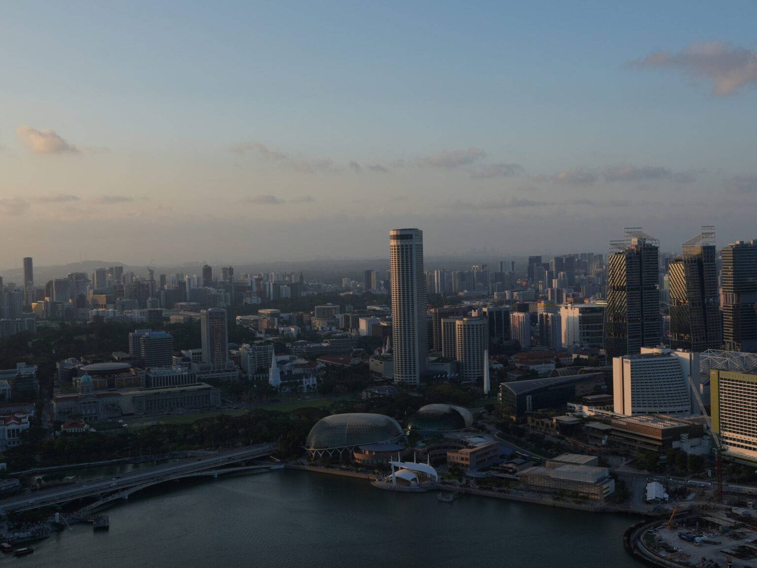Skyline von Singapur bei Sonnenuntergang, aus großer Höhe fotografiert.